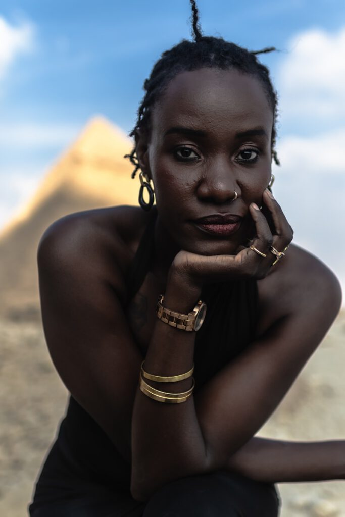 A woman sitting on the ground with her hand on her face